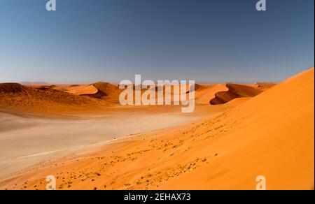 Vista panoramica gratificante dalla cima di una duna nel Parco Naukluft Namib dopo una lunga e impegnativa salita nel caldo del deserto. Foto Stock