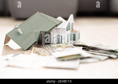 Il modello dei costi della casa su un mucchio di banconote. Acquisto e vendita Foto Stock