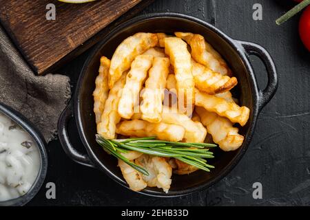 Cumulo di patatine fritte set, su sfondo nero, vista dall'alto piatto Foto Stock