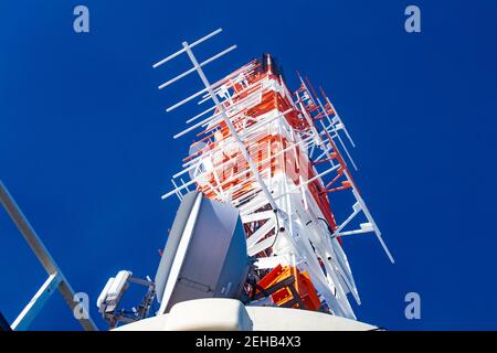 Asta dell'antenna sulla parte superiore della torre della TV di Stoccarda rossa e. struttura tecnica bianca contro il cielo blu Foto Stock