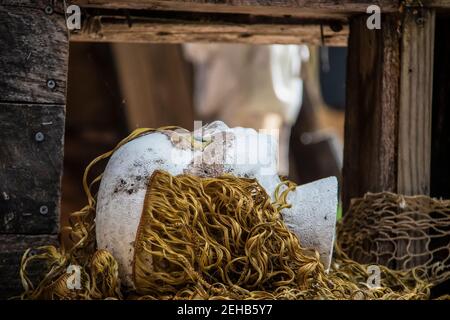 Scena horror spoky della testa della bambola in polistirolo con parte di capelli mancanti e strana textured faccia con nave pirata di legno e la pesca prossimo sfondo - v Foto Stock