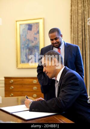 Il presidente Barack Obama firma la proclamazione che segna la Giornata Nazionale di preghiera nell'Ufficio ovale della Casa Bianca 7 maggio 2009. Si sta guardando sopra Joshua DuBois, direttore dell'Ufficio della Casa Bianca per i partenariati di fede e di vicinato. Foto ufficiale della Casa Bianca di Pete Souza Foto Stock