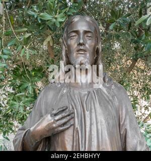 Ritratto della statua di Gesù Cristo. Sullo sfondo un olivo. Foto Stock