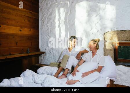 Due uomini seduti sul letto che si guardano l'uno verso l'altro Foto Stock