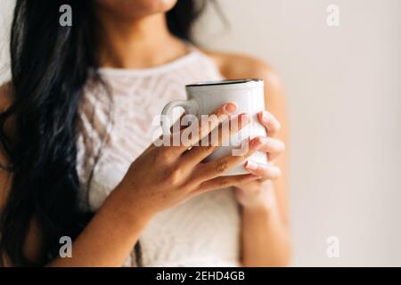 Primo piano di una donna irriconoscibile che tiene una tazza di caffè Foto Stock