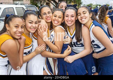 Miami Florida,Little Havana,Calle Ocho,Tres Reyes Magos Three 3 Kings Parade,studenti ispanici della scuola superiore cheerleaders uniformi amici sorridenti ragazzi Foto Stock