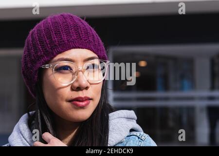 Ritratto di una donna asiatica con un cappello viola per strada Foto Stock