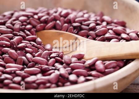 Fagioli di rene asciugati in una ciotola di legno con cucchiaio Foto Stock