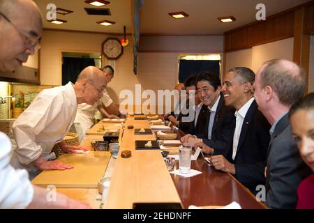Il presidente Barack Obama e il primo ministro giapponese Shinzo Abe parlano con il maestro del sushi Jiro Ono, proprietario del ristorante sushi Sukiyabashi Jiro, durante una cena a Tokyo, Giappone, il 23 aprile 2014. Foto Stock