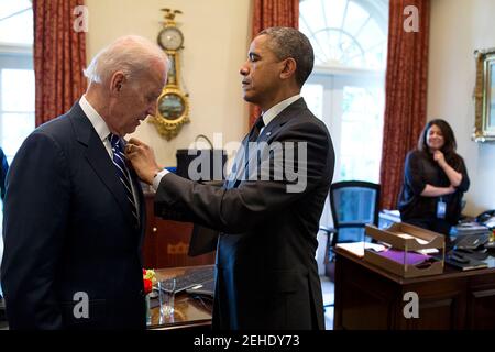 Il presidente Barack Obama regola una spilla per il Vice Presidente Joe Biden nella parte esterna Ufficio Ovale, 23 maggio 2014. Ferial Govashiri, Assistente personale del presidente si erge a destra. Foto Stock