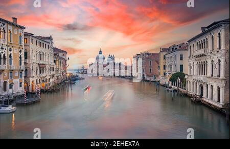 Vista mozzafiato dello skyline di Venezia con il Canal Grande e la Basilica di Santa Maria della Salute in lontananza durante una splendida alba. Foto Stock