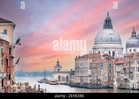 Vista mozzafiato dello skyline di Venezia con il Canal Grande e la Basilica di Santa Maria della Salute in lontananza durante una splendida alba. Foto Stock