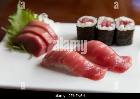 Sashimi di tonno e sushi disposti su piatto bianco Foto Stock