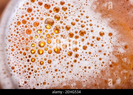 Birra chiara con bolle e schiuma di fondo. Bolle di birra texture Close Up. Foto Stock