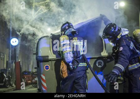 Barcellona, Spagna. 19 Feb 2021. Durante le dimostrazioni, i vigili del fuoco vengono visti spegnere il fuoco dai contenitori dei rifiuti. Quarta notte di proteste e rivolte in risposta all'arresto e alla detenzione del rapper Pablo Hasel accusato di esalare il terrorismo e di insultare la corona dal contenuto dei testi delle sue canzoni. Credit: SOPA Images Limited/Alamy Live News Foto Stock