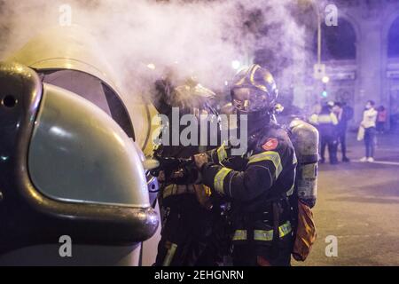 Barcellona, Spagna. 19 Feb 2021. Durante le dimostrazioni, i vigili del fuoco vengono visti spegnere il fuoco dai contenitori dei rifiuti. Quarta notte di proteste e rivolte in risposta all'arresto e alla detenzione del rapper Pablo Hasel accusato di esalare il terrorismo e di insultare la corona dal contenuto dei testi delle sue canzoni. Credit: SOPA Images Limited/Alamy Live News Foto Stock