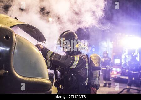 Barcellona, Spagna. 19 Feb 2021. Durante le dimostrazioni, i vigili del fuoco vengono visti spegnere il fuoco dai contenitori dei rifiuti. Quarta notte di proteste e rivolte in risposta all'arresto e alla detenzione del rapper Pablo Hasel accusato di esalare il terrorismo e di insultare la corona dal contenuto dei testi delle sue canzoni. Credit: SOPA Images Limited/Alamy Live News Foto Stock