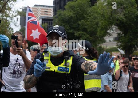 Melbourne, Australia. 20 febbraio 2021. I manifestanti vengono incontrati dalla polizia mentre marciano contro le vaccinazioni obbligatorie per il coronavirus. Gli organizzatori hanno dichiarato che i ‘millions’ marcieranno in tutta l’Australia in undici luoghi diversi, anche se questo numero potrebbe essere esagerato in modo massiccio. 20 febbraio 2021. Melbourne, Australia. Credit: Jay Kogler/Alamy Live News Foto Stock