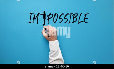 Mano maschile disegnando una silhouette uomo d'affari, trasformando la parola impossibile in possibile spingendo via le lettere. Aspirazione, positività, credenza Foto Stock
