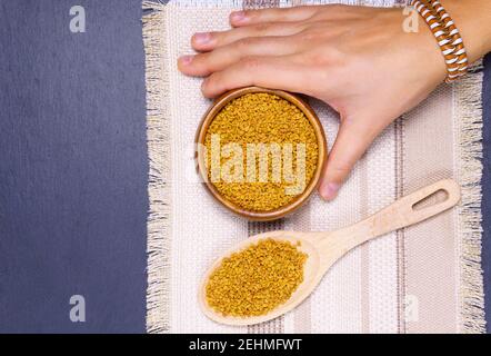 Semi di fenugreek in ciotola di legno, spezie, ingrediente culinario, closeup di shamballa Foto Stock