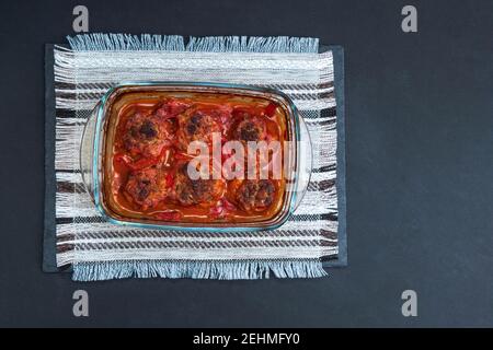 Polpette con salsa di pomodoro in primo piano con coperchio della teglia. Cucina fatta in casa. copyspace Foto Stock