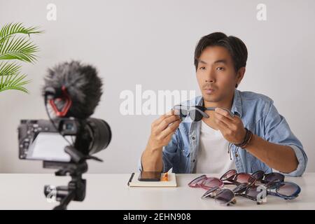 Asian Vlogger o Blogger in Jean Shirts Rivedi occhiali di Moda neri e Video di registrazione. Freelance Online Live Streaming con il cliente tramite Social Me Foto Stock