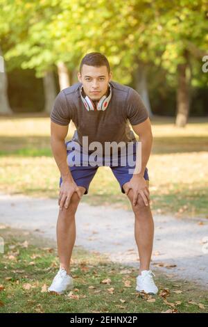 Runner sport allenamento fitness giovane latino uomo pronto inizio un ritratto di parco all'aperto Foto Stock