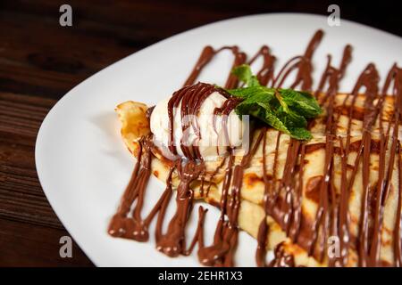 Pancake con un cucchiaio di gelato e cioccolato. Primo piano, messa a fuoco selettiva Foto Stock