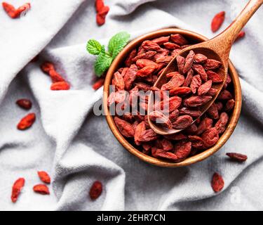 Bacche rosse di goji asciutte per una dieta sana su a. sfondo tessuto Foto Stock