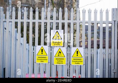 Sito in costruzione per la salute e la sicurezza regole messaggio di segno segnaletica scheda sul confine di recinzione Foto Stock