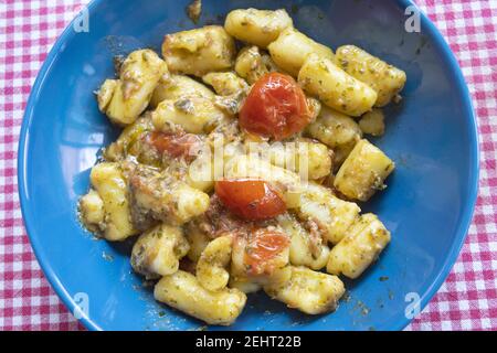 gnocchi di patate con salsa al pesto e pomodori ciliegini Foto Stock