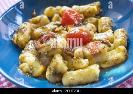 gnocchi di patate con salsa al pesto e pomodori ciliegini Foto Stock