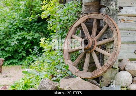 Vecchia ruota di legno nel willage vicino a vecchia casa wodden in Lituania Foto Stock