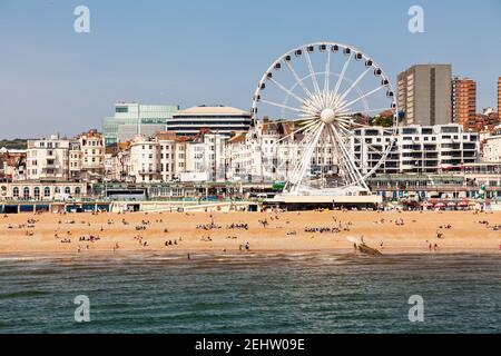 BRIGHTON, Regno Unito - 5 GIU 2013: Holidayers godendo di buone condizioni atmosferiche in corrispondenza di spiaggia di ciottoli vicino alla ruota panoramica su una soleggiata giornata estiva Foto Stock