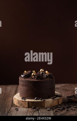 vista frontale della torta al cioccolato, con patatine al cioccolato, cucchiaio e tavolo in legno. Foto Stock