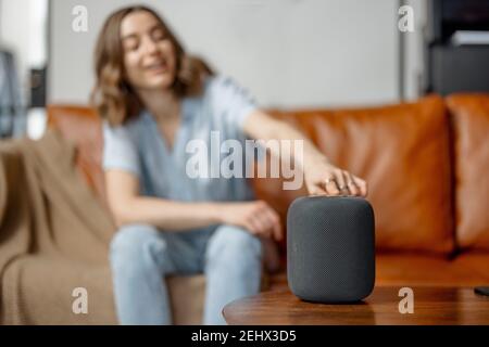 Donna che parla con la colonna dell'assistente audio Foto Stock