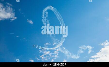 Velivoli acrobatici che eseguono incredibili acrobazie. Acrobazie di manovra aerea. Gli aerei si snodano con sentieri di fumo Foto Stock