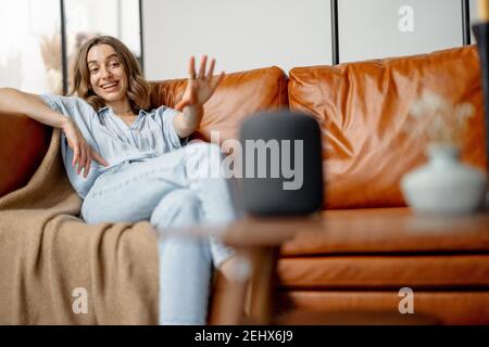 Donna che parla con la colonna dell'assistente audio Foto Stock