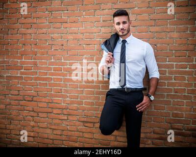 Elegante e bello, giovane uomo che indossa abiti da lavoro Foto Stock