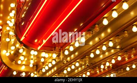 Le vecchie lampade elettriche che funzionano lampeggiano e si illuminano di notte. Primo piano astratto della decorazione del casinò retrò scintillante a Las Vegas, Stati Uniti. Luce di colore Foto Stock