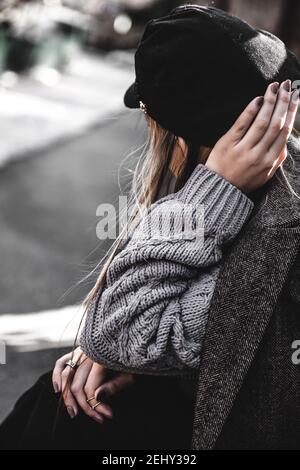 Ritratto in stile streetstyle di giovane donna che indossa abiti colorati in maglia sulla strada. Outdoor, strada, stile di vita. Concetto di freelance, creatrice fai da te Foto Stock