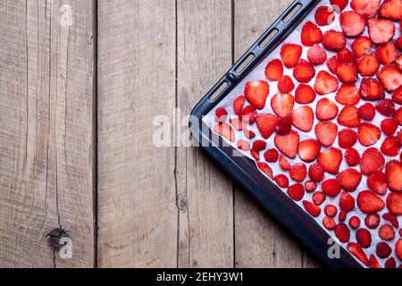 frutta. Cottura di fragole su una piastra di metallo scuro in forno. Foto Stock