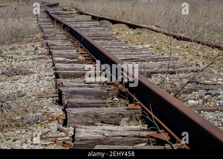 Vecchie rotaie arrugginite nel sole primaverile. Foto Stock