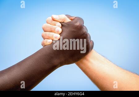 Mani umane nere e bianche in un moderno handshake a. Mostra a vicenda amicizia e rispetto - braccio lottando contro razzismo Foto Stock