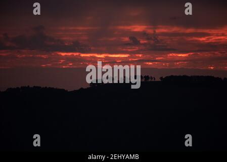 Silhouette degli alberi sulla collina catturata a a. magnifico tramonto Foto Stock