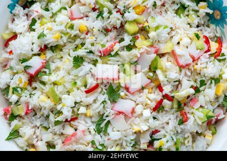 I bastoncini di granchio e la insalata di riso da vicino. Piatto vegetariano. Foto Stock