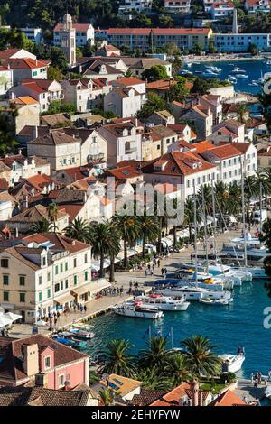 Città di Hvars Busy Boat Port, strada con persone, case e tetti Foto Stock
