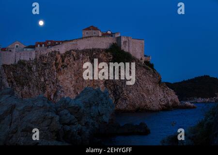 Fotografia notturna della città di pareti di Setsniks su una scogliera Con Luna piena e Mare sullo sfondo Foto Stock