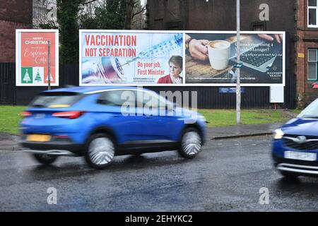 Greenock, Scozia, Regno Unito. 20 febbraio 2021. Nella foto: Immagine del primo ministro scozzese Nicola Sturgeon con la grafica di un vaccino COVID19 e una siringa con lo slogan: "VACCINAZIONE NON SEPARAZIONE. FAI IL TUO LAVORO, PRIMO MINISTRO." su un cartellone nel mezzo di Greenock, in un crocevia trafficato di Brougham St & Campbell St. Questo è in riferimento alla maggioranza silenziosa di persone in Scozia che si oppongono alla SNP cercando un secondo referendum sull'indipendenza nel mezzo di una pandemia che lo ha fatto Nel Regno Unito sono state uccise oltre 106,000 persone, di cui 6,816 nella sola Scozia. Credit: Colin Fisher/Alamy Live News. Foto Stock