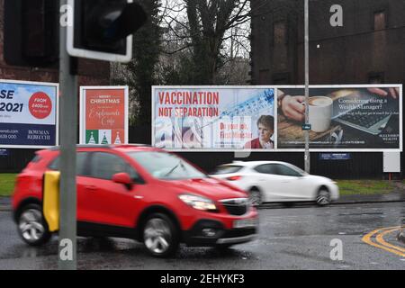 Greenock, Scozia, Regno Unito. 20 febbraio 2021. Nella foto: Immagine del primo ministro scozzese Nicola Sturgeon con la grafica di un vaccino COVID19 e una siringa con lo slogan: "VACCINAZIONE NON SEPARAZIONE. FAI IL TUO LAVORO, PRIMO MINISTRO." su un cartellone nel mezzo di Greenock, in un crocevia trafficato di Brougham St & Campbell St. Questo è in riferimento alla maggioranza silenziosa di persone in Scozia che si oppongono alla SNP cercando un secondo referendum sull'indipendenza nel mezzo di una pandemia che lo ha fatto Nel Regno Unito sono state uccise oltre 106,000 persone, di cui 6,816 nella sola Scozia. Credit: Colin Fisher/Alamy Live News. Foto Stock